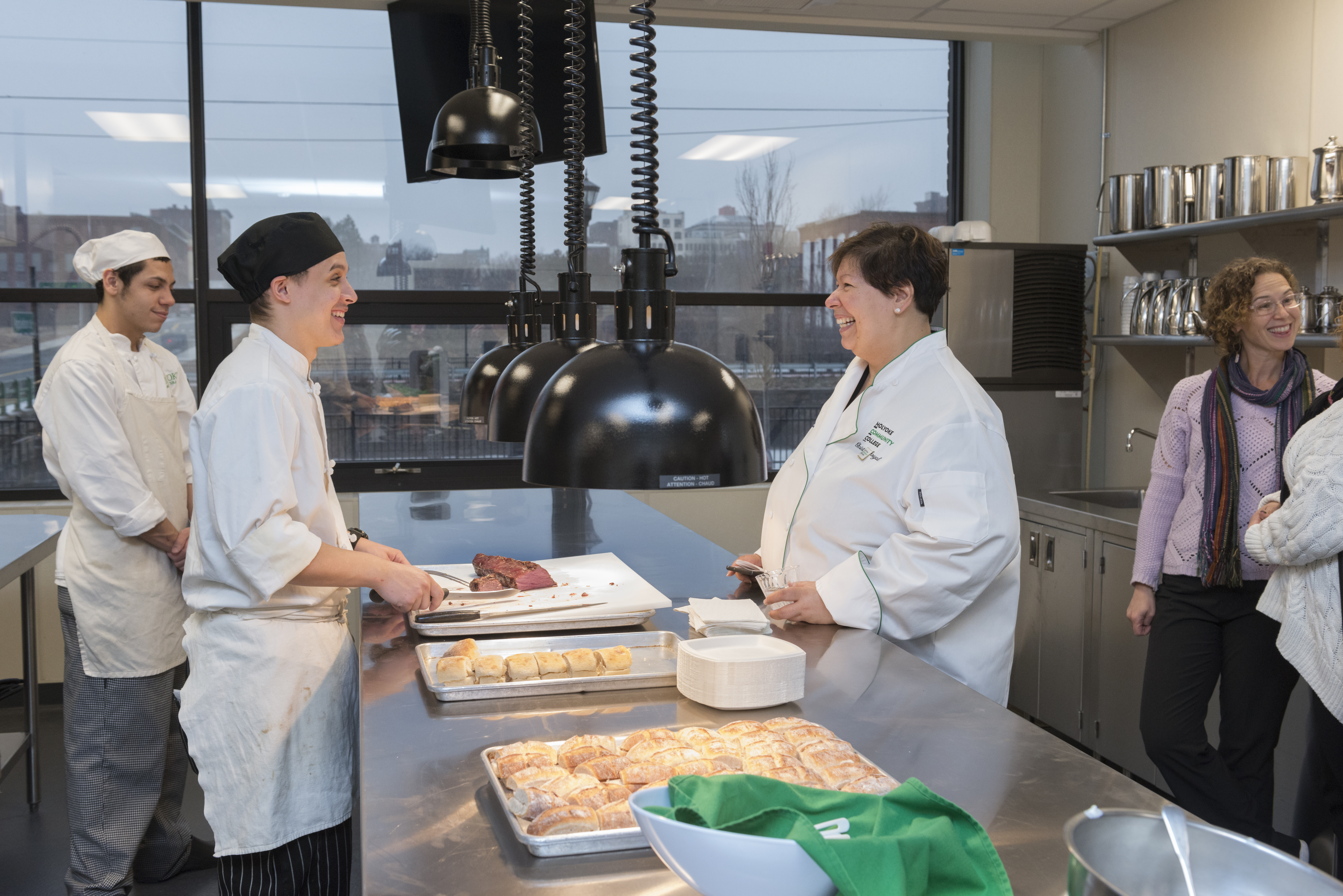 Christina Royal smiles at a student in culinary arts kitchen